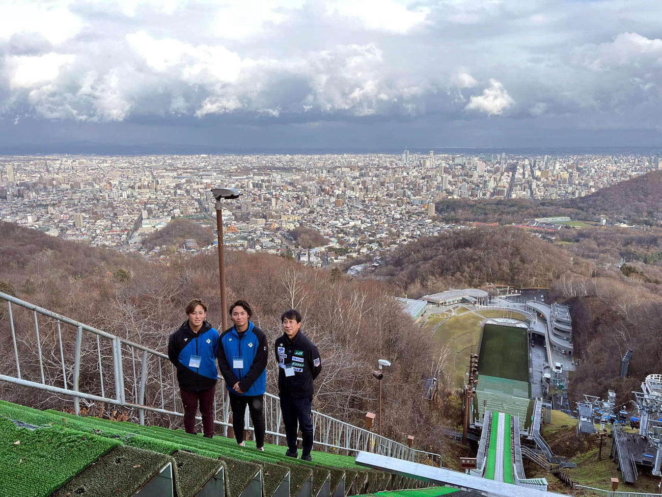札幌の町並みをバックに大倉山ジャンプ競技場に立つ（左から）日本ハム河野、伊藤、原田氏（撮影・永野高輔）