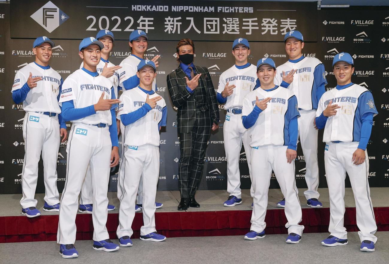 日本ハムの新入団選手発表で新庄監督（中央）と一緒にポーズをとる選手たち（共同）