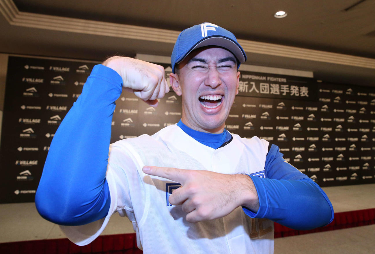 日本ハム新入団選手発表会見で自慢の「筋肉」をアピールする育成3位山口（撮影・黒川智章）