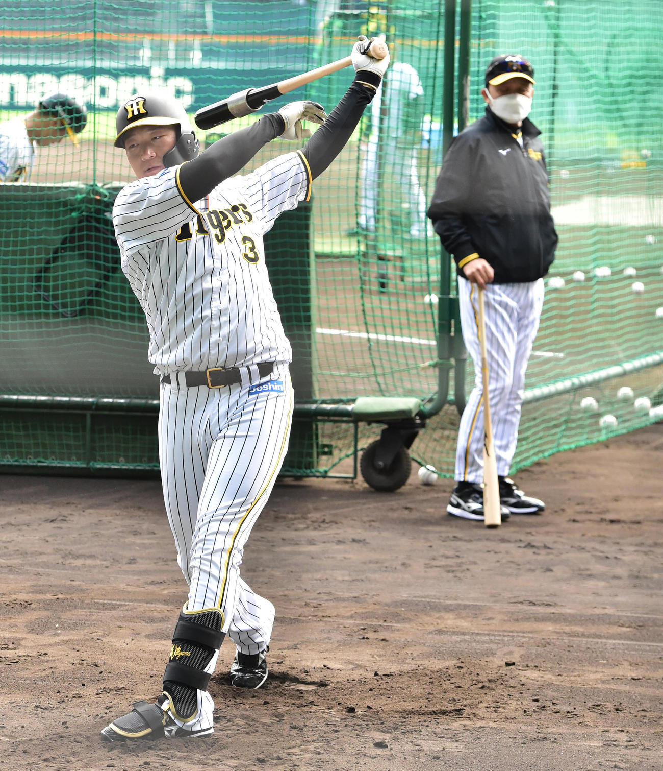 トス打撃を行う阪神大山悠輔とじっと見る岡田彰布監督（奥）（撮影・清水貴仁）