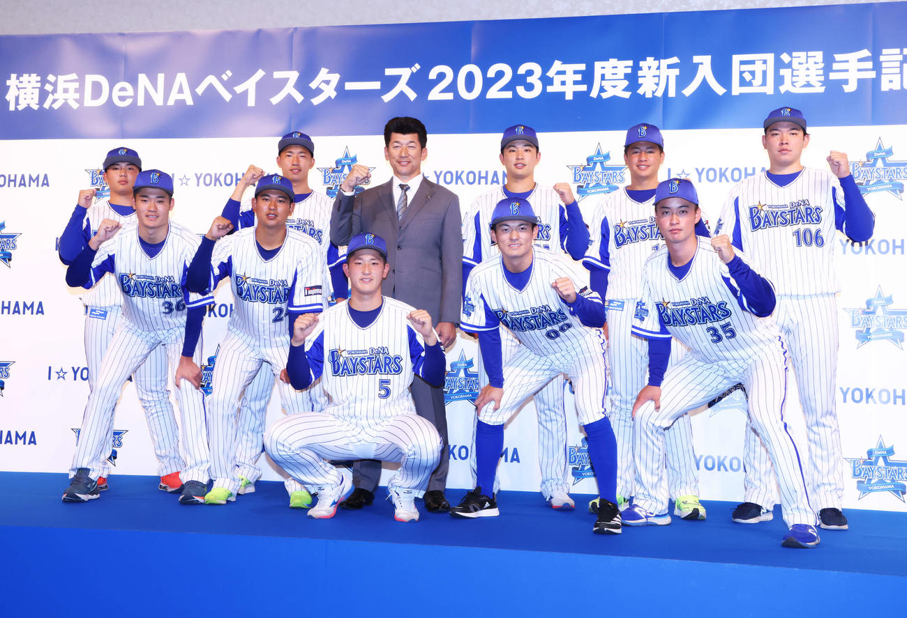 DeNA新入団選手発表会見で三浦監督（中央）と集合写真に納まる新入団選手たち。前列左から森下、吉野、松尾、林、橋本、後列左から草野、今野、1人おいて上甲、鈴木、渡辺（撮影・河田真司）