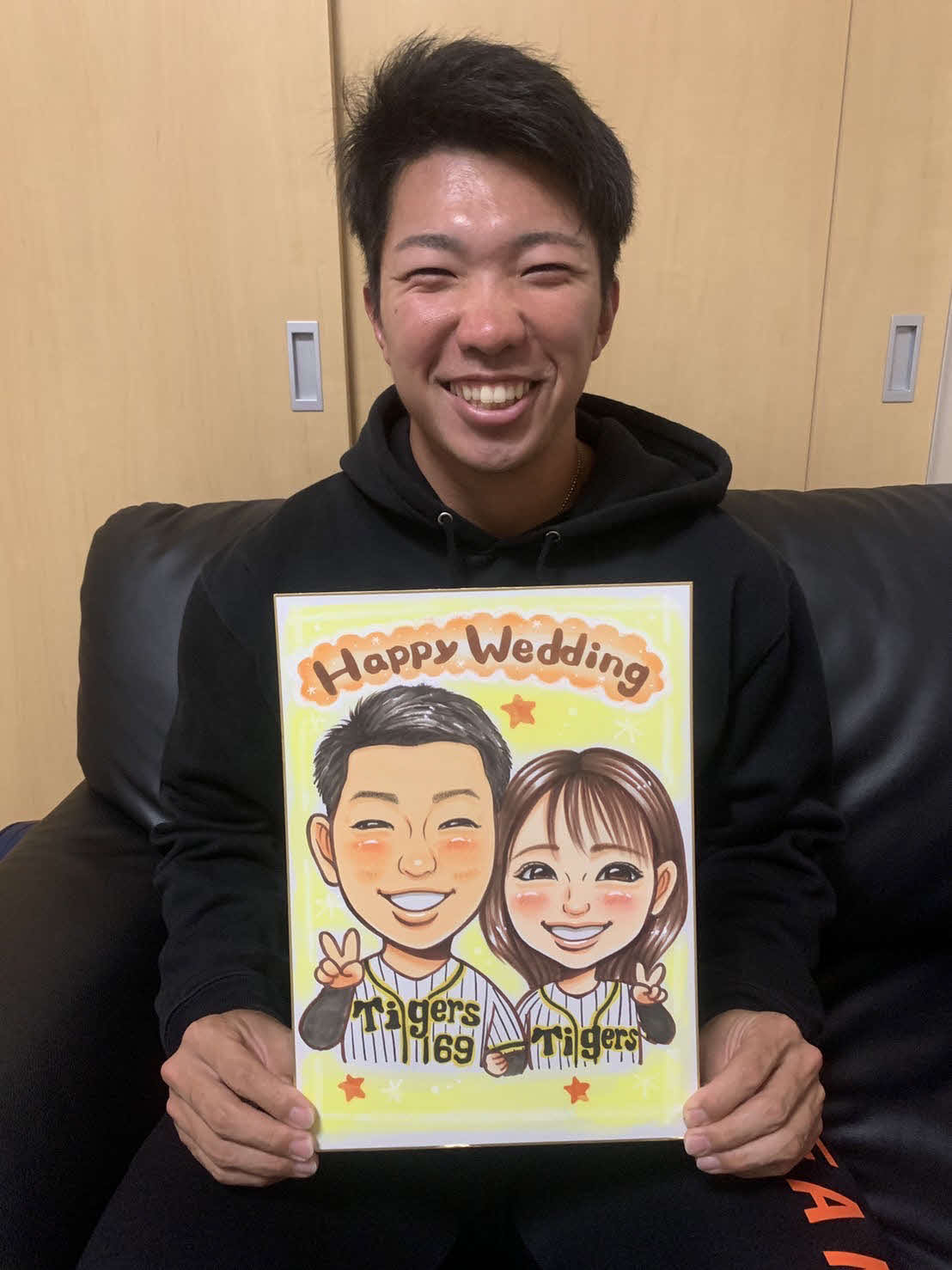 2人の似顔絵を手に笑顔の阪神石井