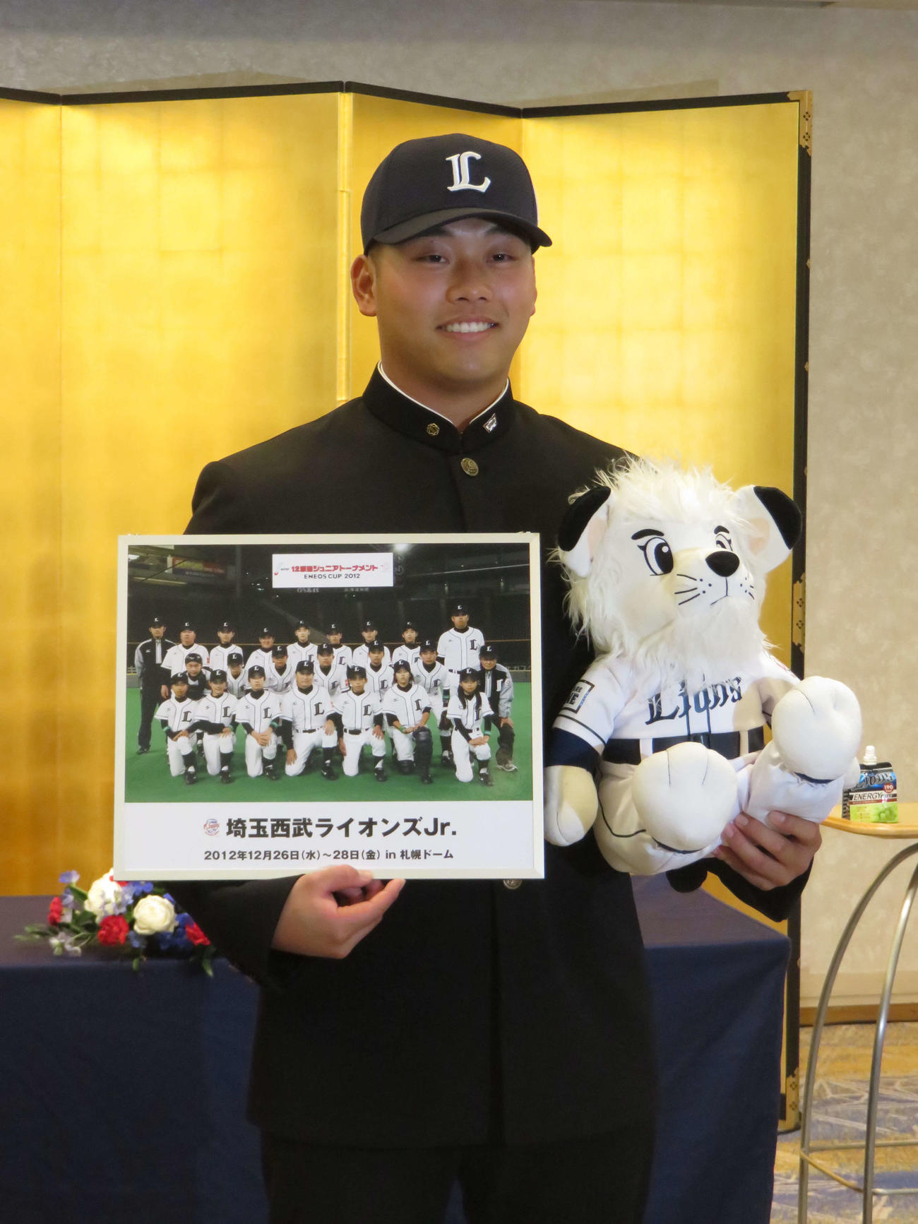 契約交渉を終え、ライオンズジュニア時代の写真とレオ人形を手に笑顔の早大・蛭間