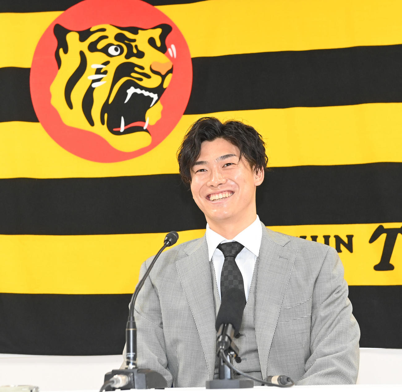 大幅アップで契約更改し笑顔で会見する湯浅（撮影・前岡正明）