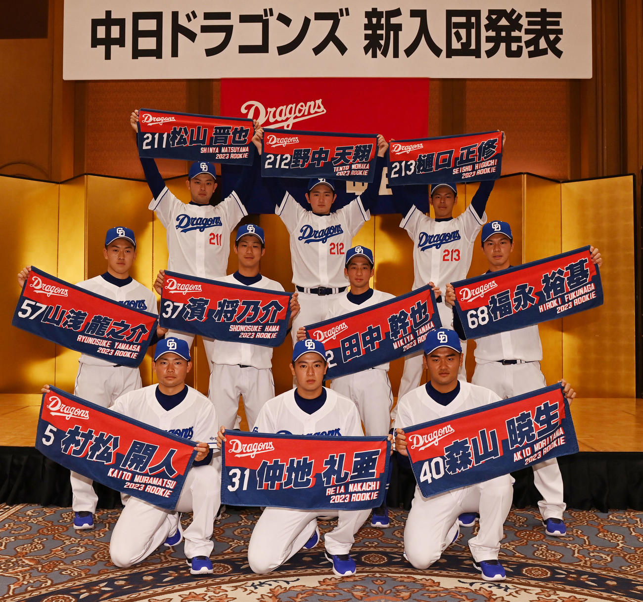 会見後、自身のネーム入りタオルを手にに記念撮影をする（前列・左から）村松、仲地、森山（中列・左から）山浅、浜、田中、福永（後列・左から）松山、野中、樋口（撮影・森本幸一）
