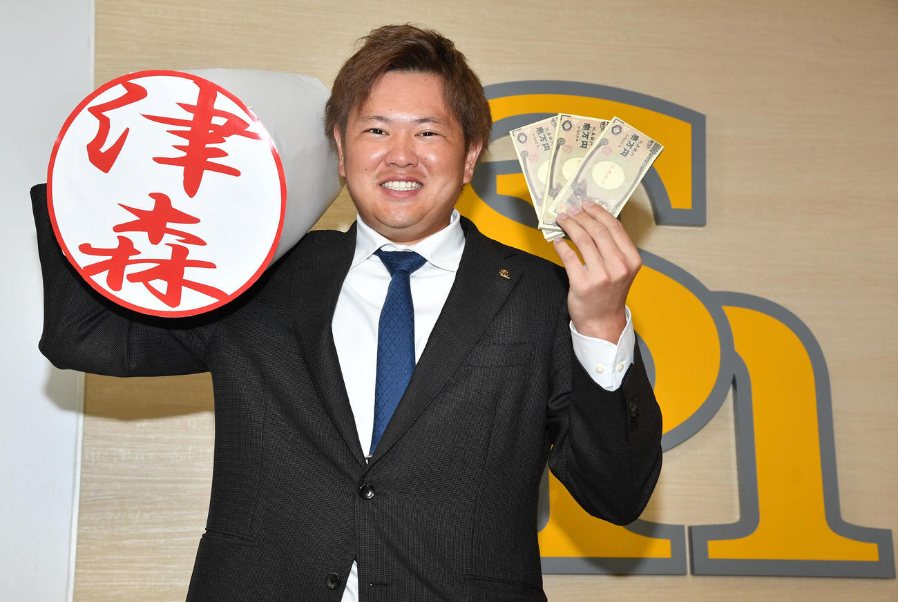 契約更改を終え、ハンコを手に笑顔で記念撮影する津森（撮影・岩下翔太）