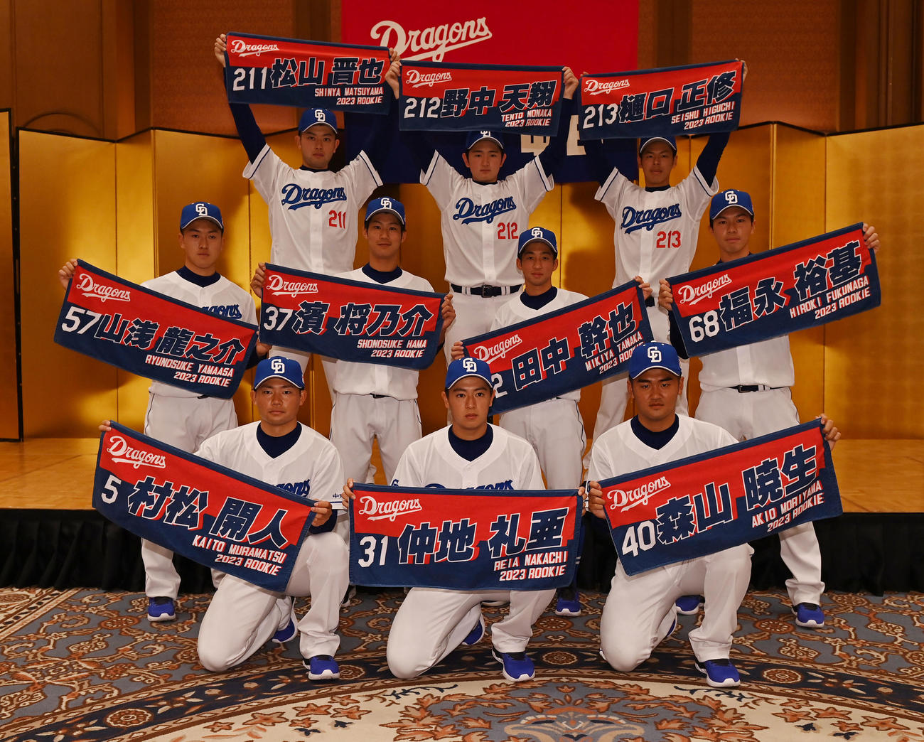 会見後、自身のネーム入りタオルを手にに記念撮影をする（前列・左から）村松、仲地、森山（中列・左から）山浅、浜、田中、福永（後列・左から）松山、野中、樋口（撮影・森本幸一）