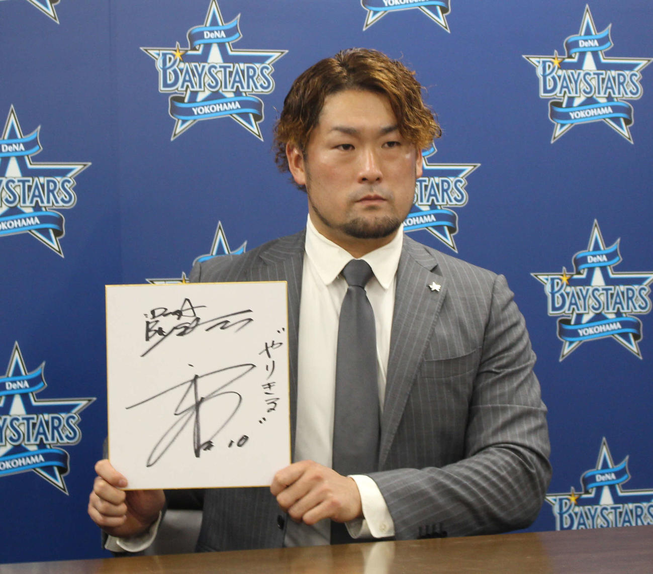 契約更改交渉を終え、色紙を手に写真に納まるDeNA戸柱（撮影・久保賢吾）