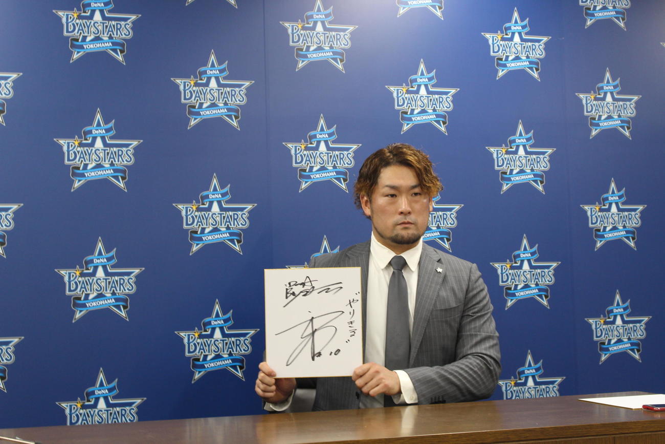 契約更改交渉を終え、色紙を手に写真に納まるDeNA戸柱（撮影・久保賢吾）