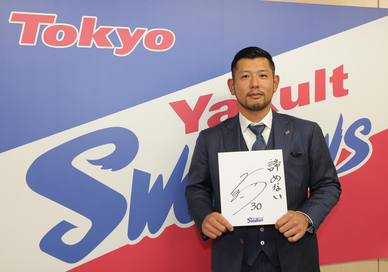 契約を更改した西田明央は来シーズンの目標を書き入れた色紙を手にポーズをとる（代表撮影）
