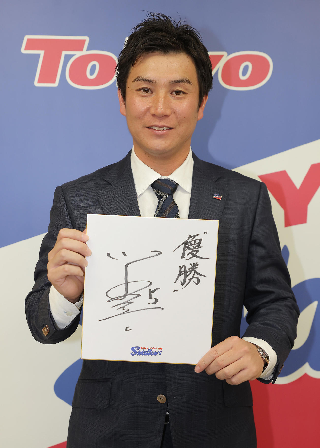 契約を更改した川端慎吾は、来シーズンの目標を書き入れた色紙を持ちポーズをとる（代表撮影）