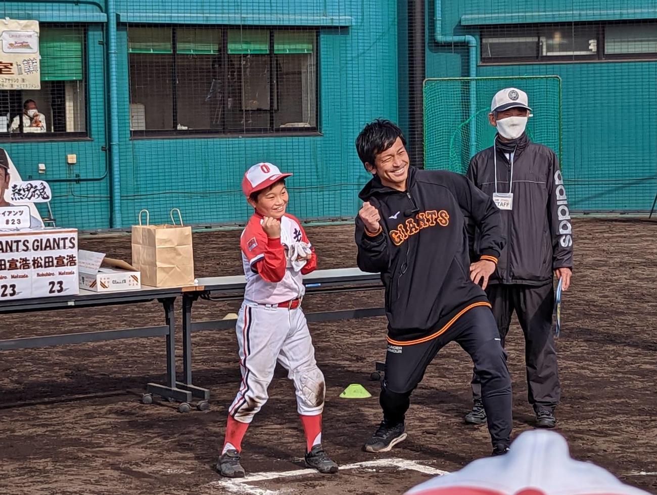 野球教室で少年と「熱男」ポーズを披露する巨人松田宣浩内野手（撮影・三須一紀）