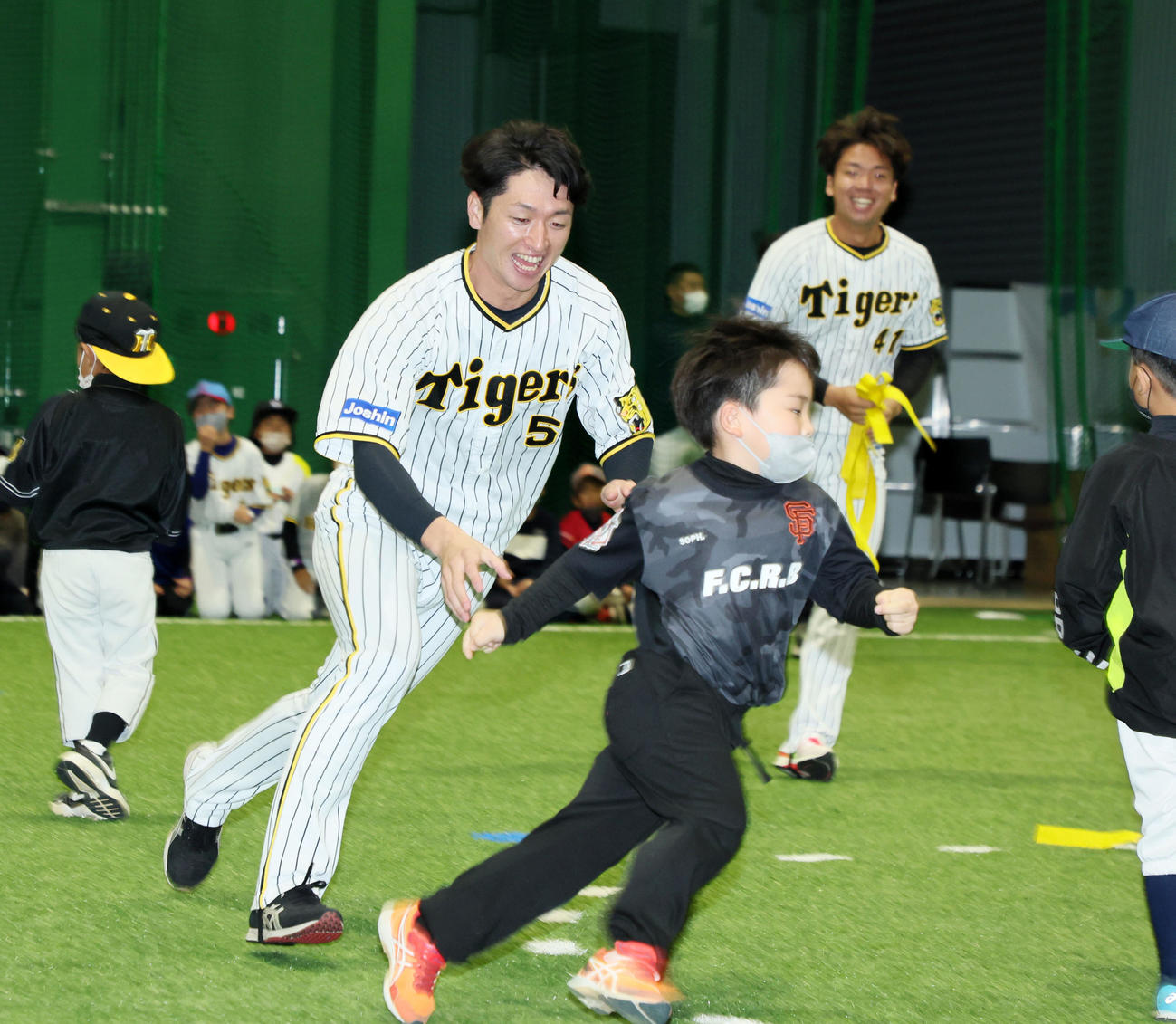淡路ふれあい運動教室で「尻尾取り」ゲームを行う近本（左）と村上（撮影・加藤哉）