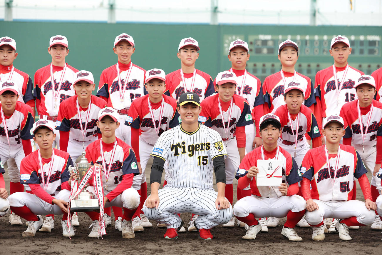 タイガースカップの表彰式でプレゼンターを務め、優勝したヤング湊クラブの選手たちと記念写真に納まる阪神西純（前列中央）（撮影・前田充）