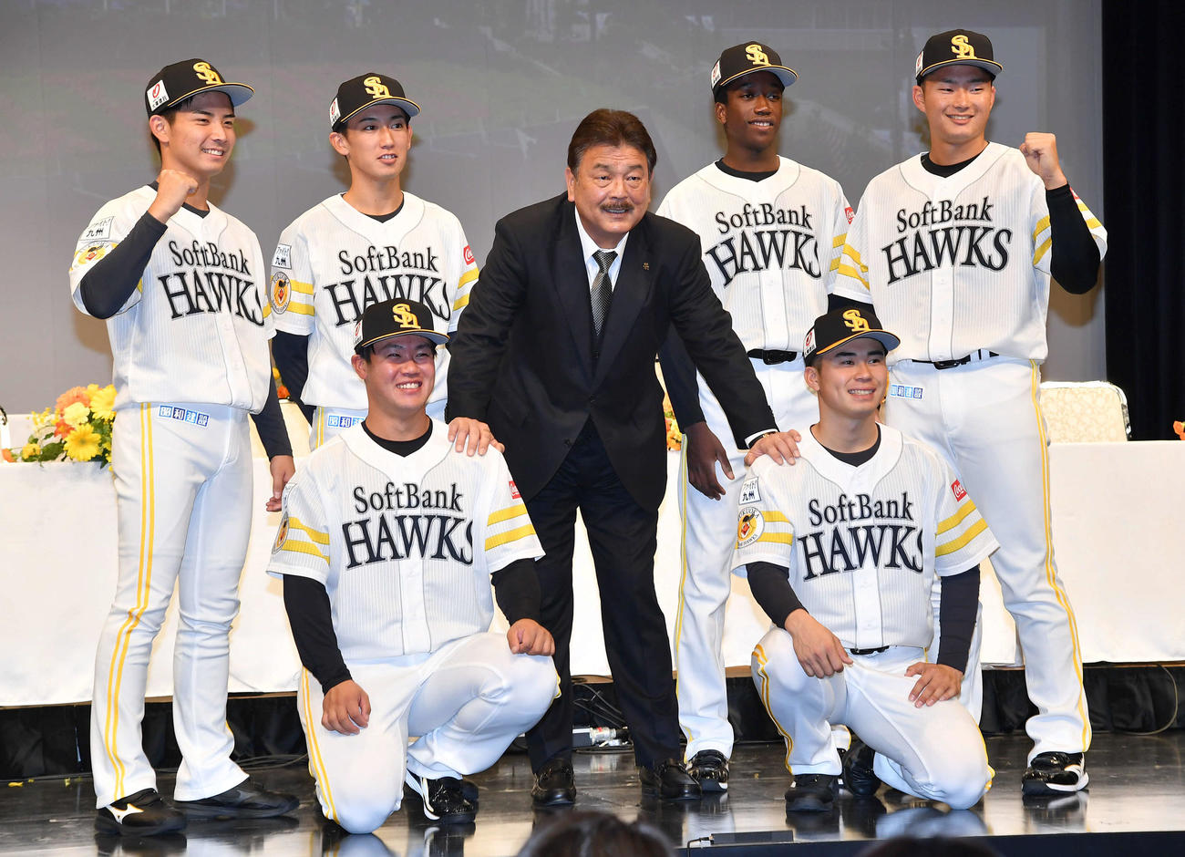 ソフトバンク藤本監督（中央）と記念撮影する、後方左からドラフト4位大野、2位大津、1人おいて1位イヒネ、3位甲斐生、前列左から6位吉田、5位松本晴（撮影・岩下翔太）