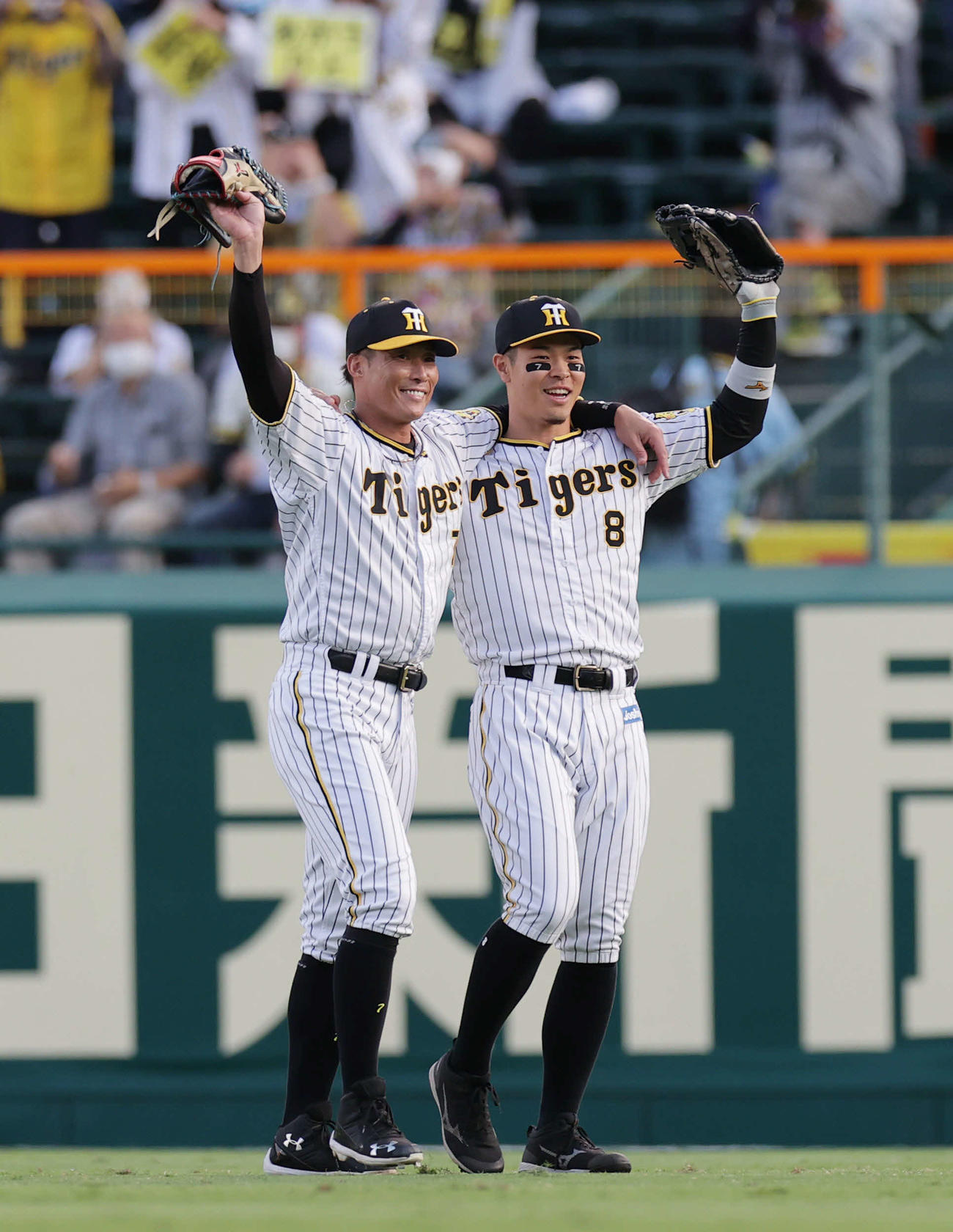 9月21日、試合前に肩を組み声援に応える糸井（左）と佐藤輝