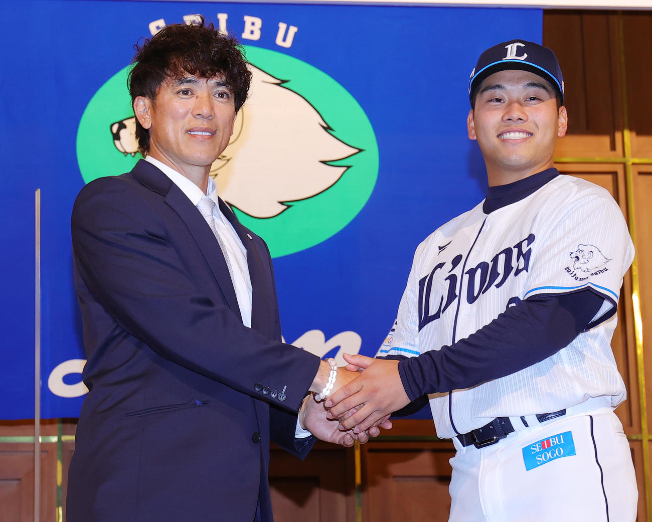 西武の新入団選手発表会で松井監督（左）と握手するドラフト1位の蛭間（撮影・野上伸悟）