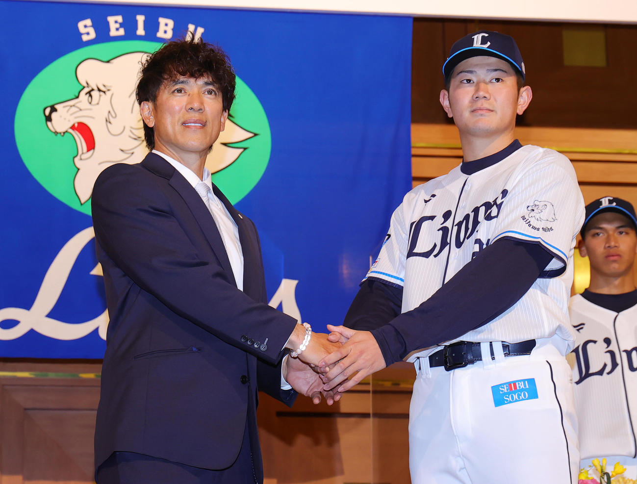 西武の新入団選手発表会で松井監督（左）と握手するドラフト4位の青山（撮影・野上伸悟）