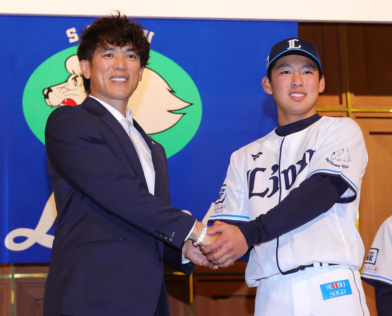 西武の新入団選手発表会で松井監督（左）と握手するドラフト5位の山田（撮影・野上伸悟）