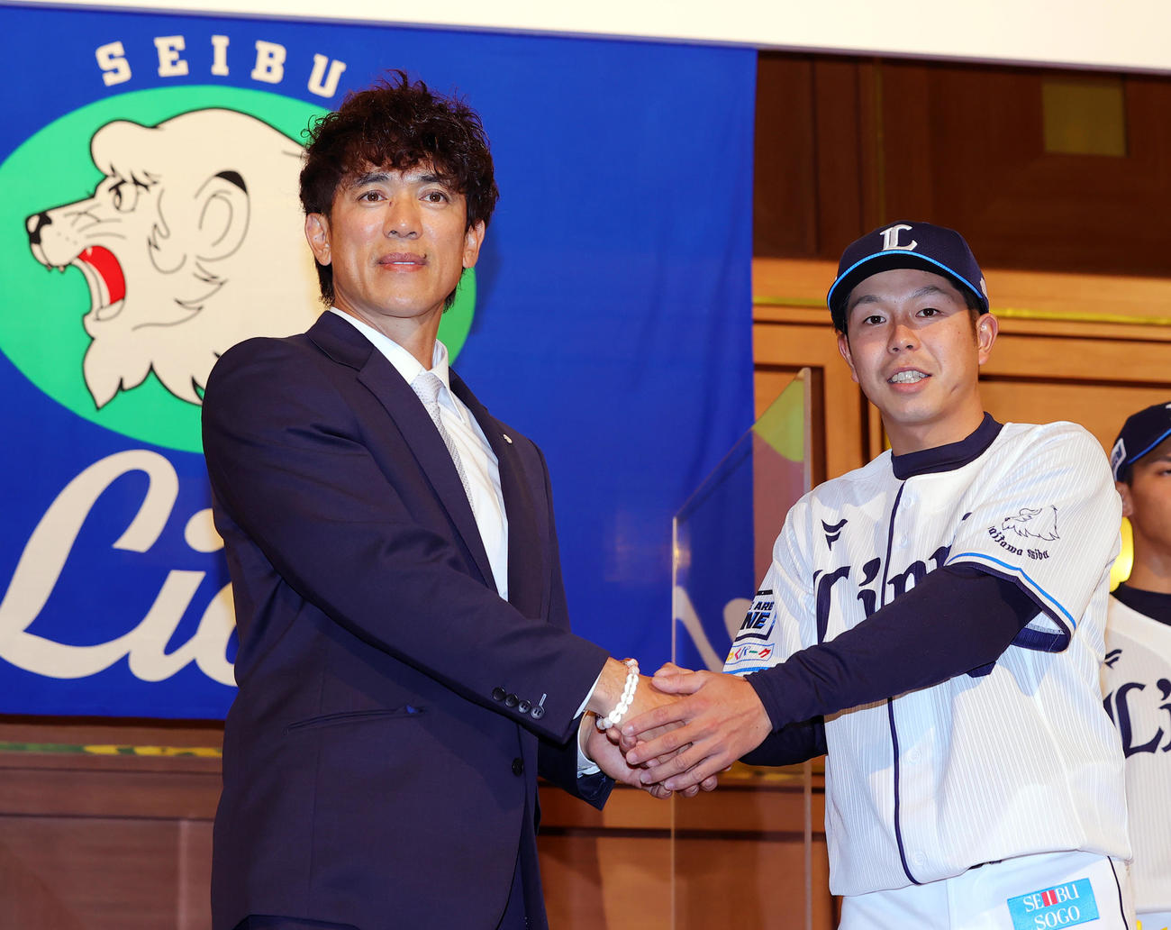 西武の新入団選手発表会で松井監督（左）と握手するドラフト6位の児玉（撮影・野上伸悟）