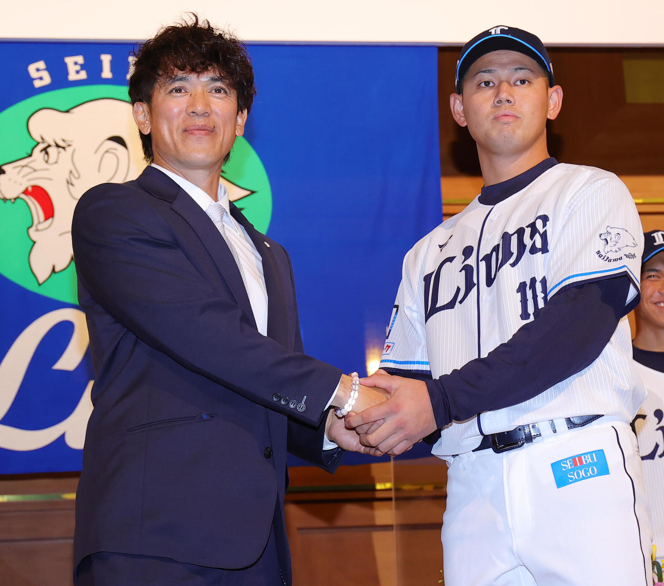 西武の新入団選手発表会で松井稼頭央監督（左）と握手する育成1位の野村（撮影・野上伸悟）