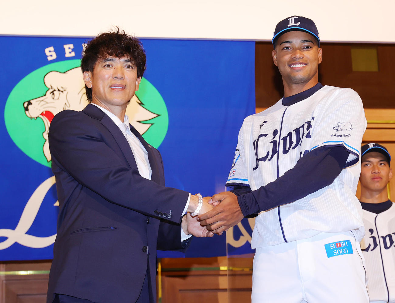西武の新入団選手発表会で松井監督（左）と握手する育成2位の日隈（撮影・野上伸悟）