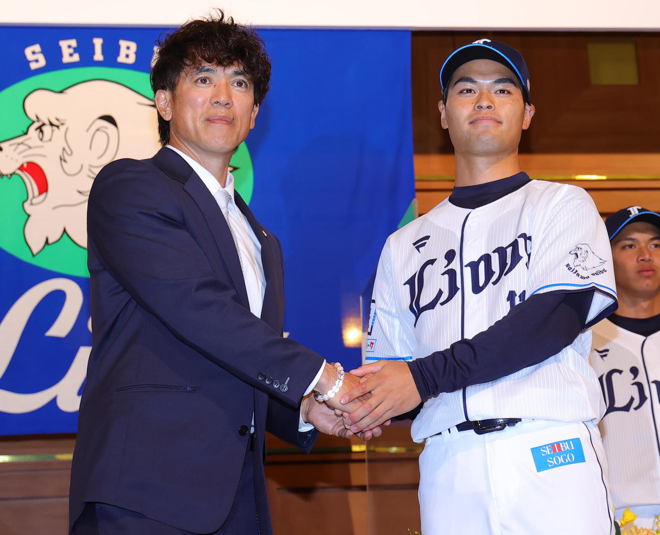 西武の新入団選手発表会で松井監督（左）と握手する育成4位の是沢（撮影・野上伸悟）