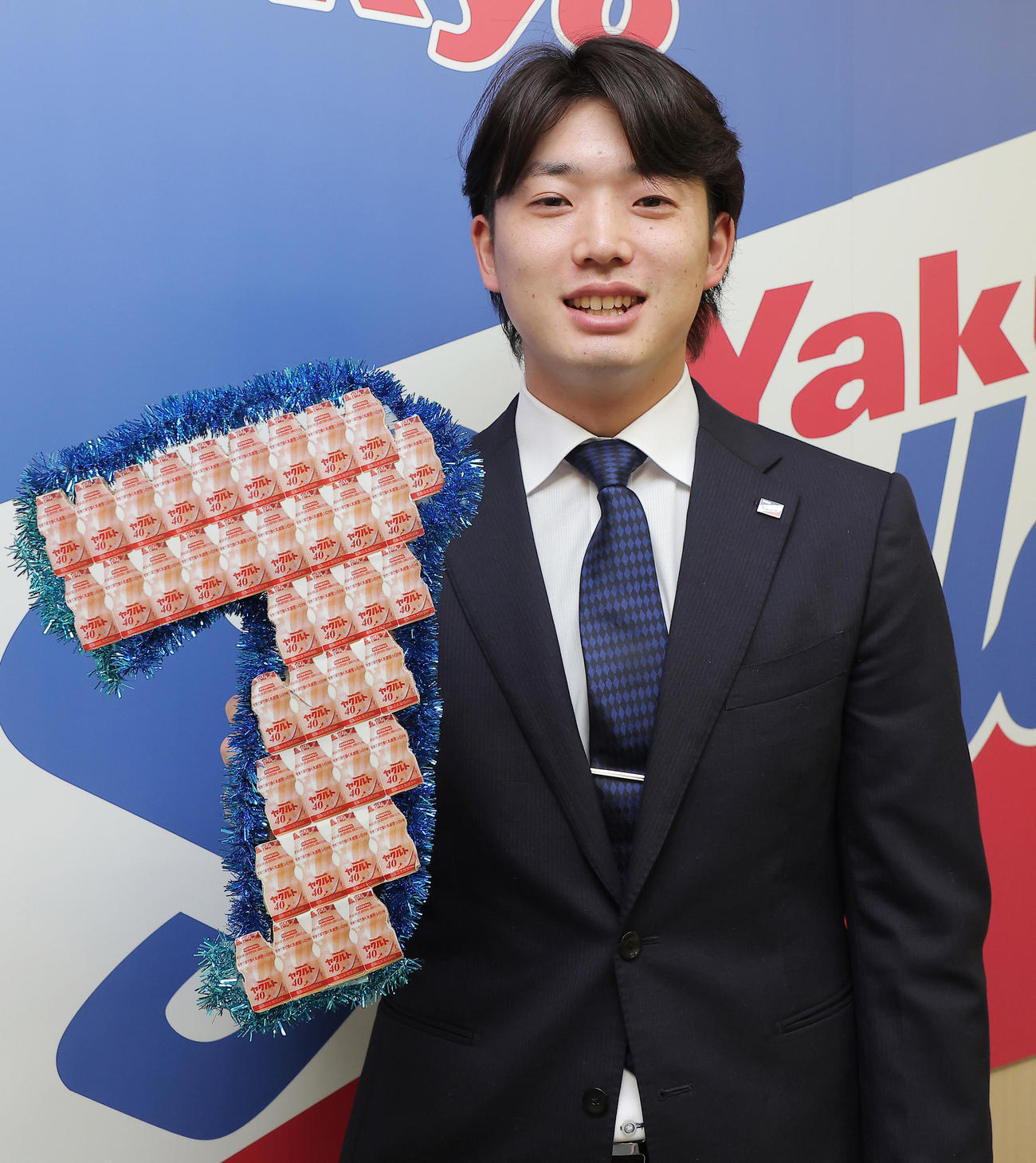 契約更改後の会見で新背番号「7」のボードを持つヤクルト長岡（代表撮影）
