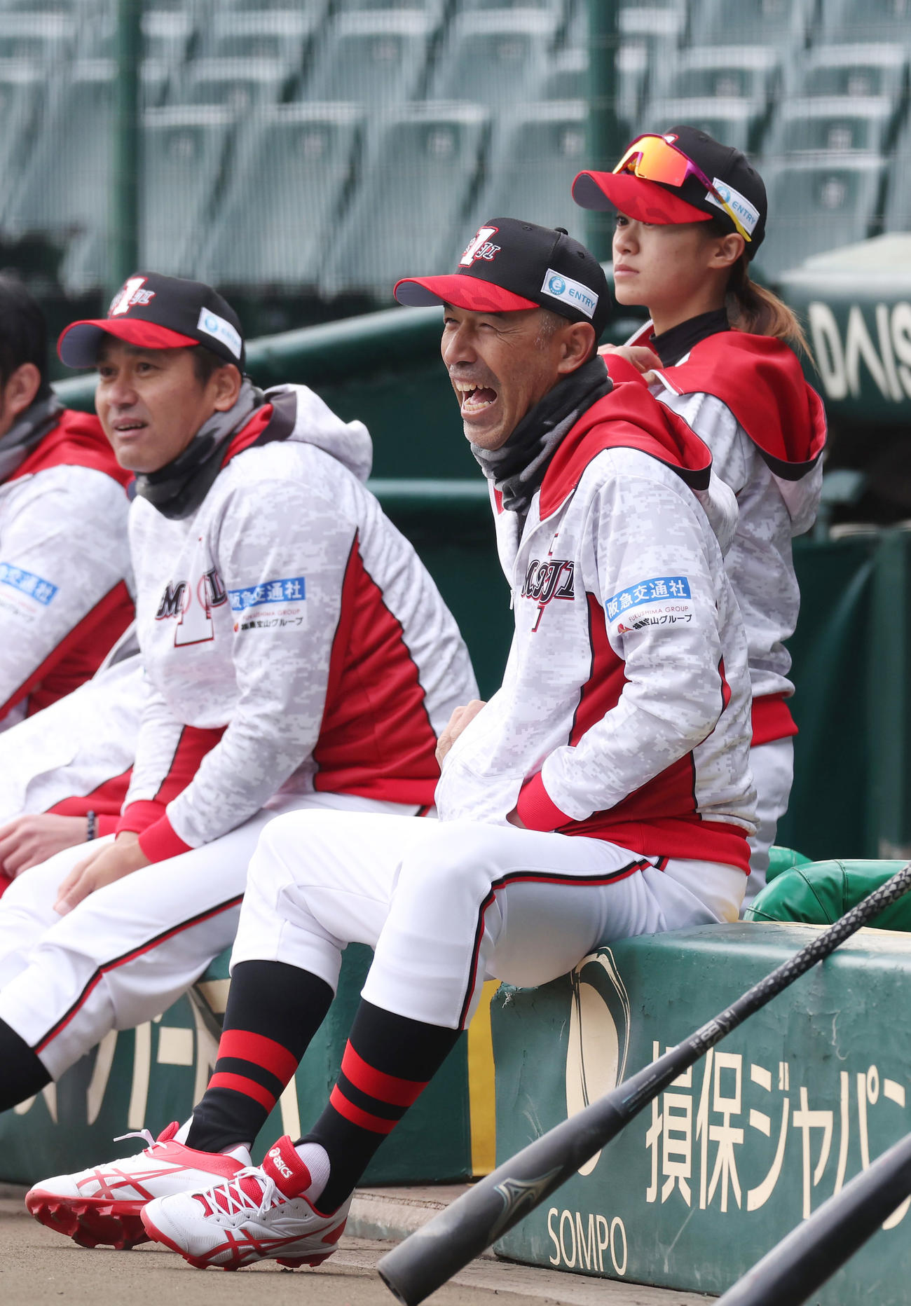 笑顔でベンチから試合を見つめる和田氏（中央）。左は黒木氏（撮影・前田充）