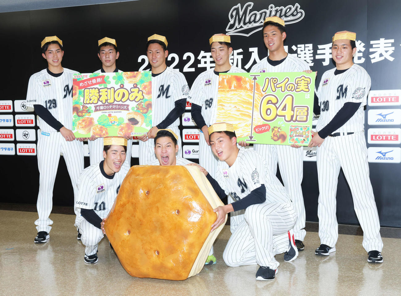 巨大パイの実と写真に納まるロッテ新入団選手。前列左から友杉、菊地、田中晴、後列左から勝又、吉川、高野、金田、白浜、黒川（撮影・河田真司）