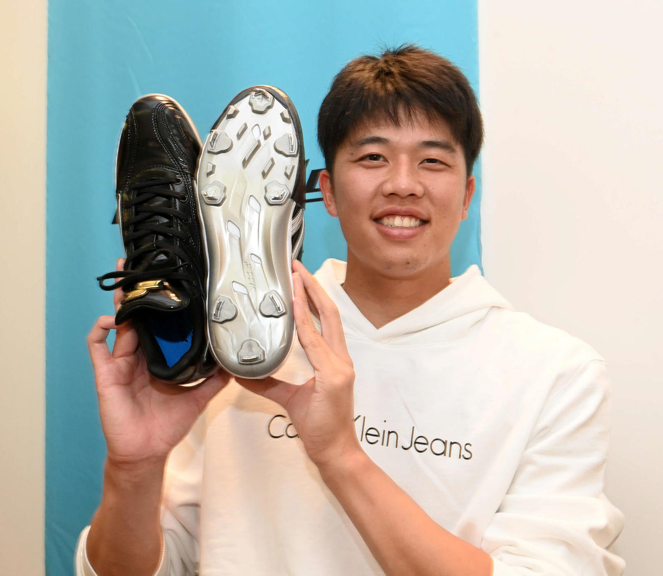 来シーズンから使用する新スパイクを手に笑顔を見せる阪神才木（撮影・前岡正明）