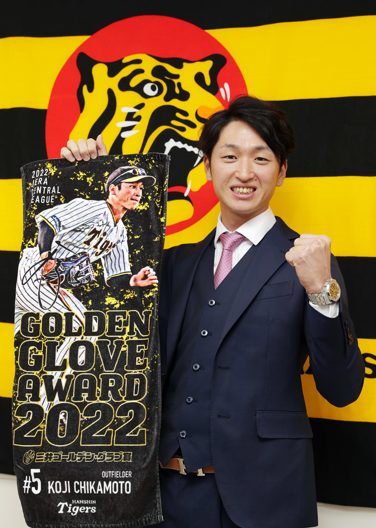 契約更改を終えた近本は、ゴールデングラブ賞を記念した球団グッズを手にガッツポーズ（撮影・前田充）