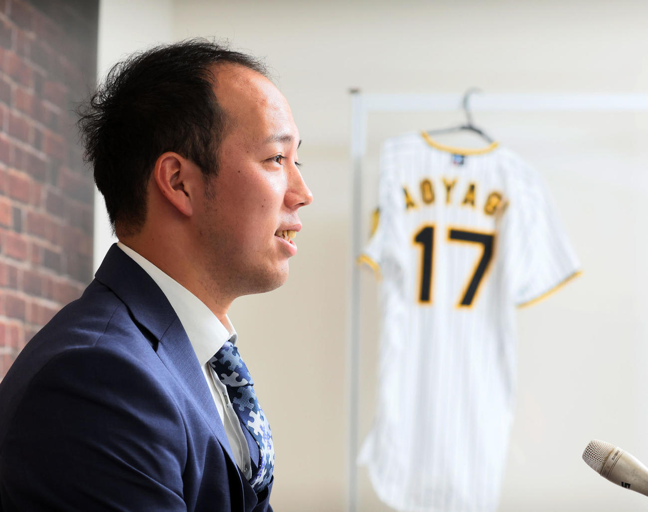 新背番号「17」番のユニホームを横目に契約更改の会見をする青柳（撮影・加藤哉）