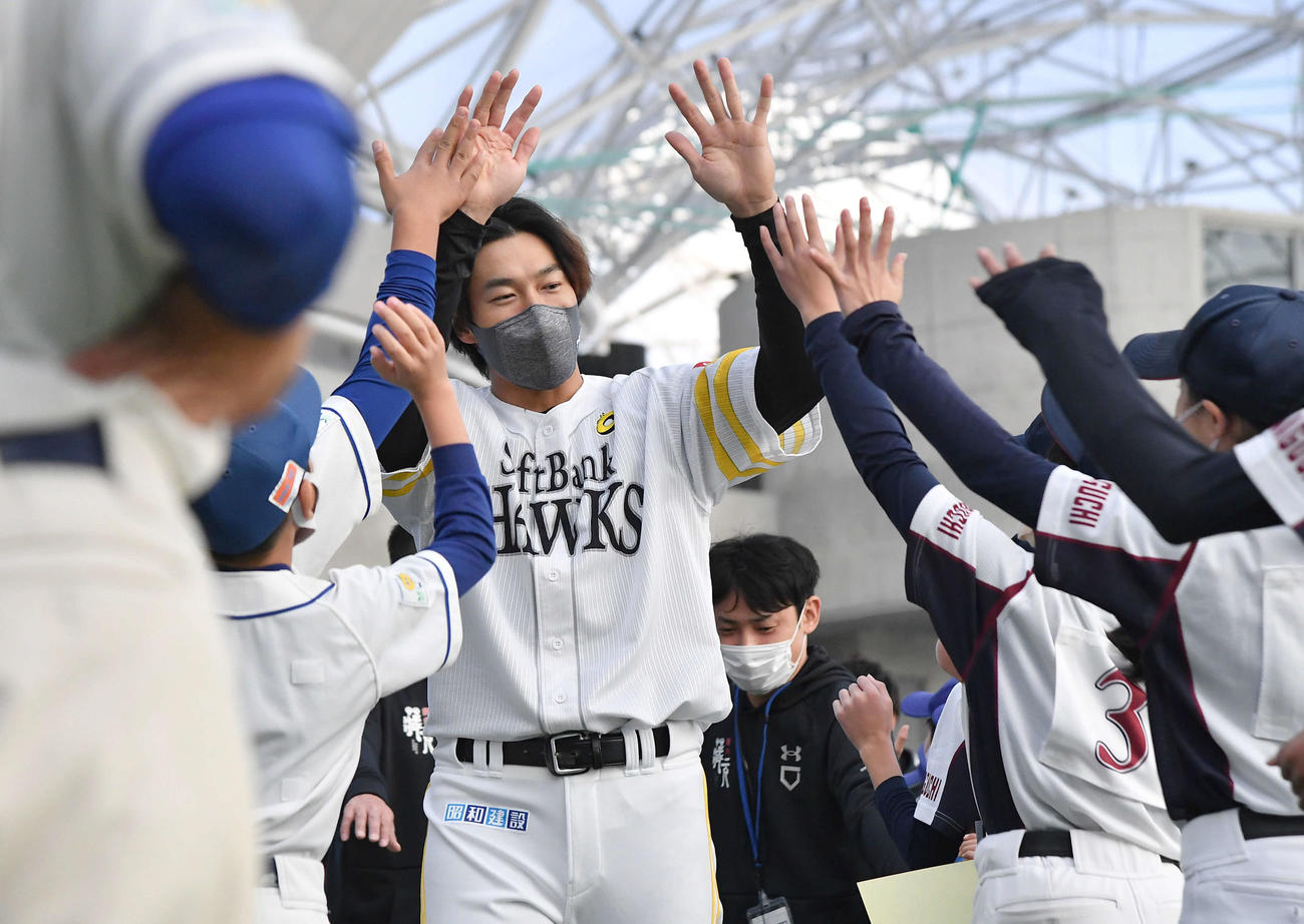 野球教室を終え、子どもたちとハイタッチしながら引き揚げる柳田（撮影・岩下翔太）