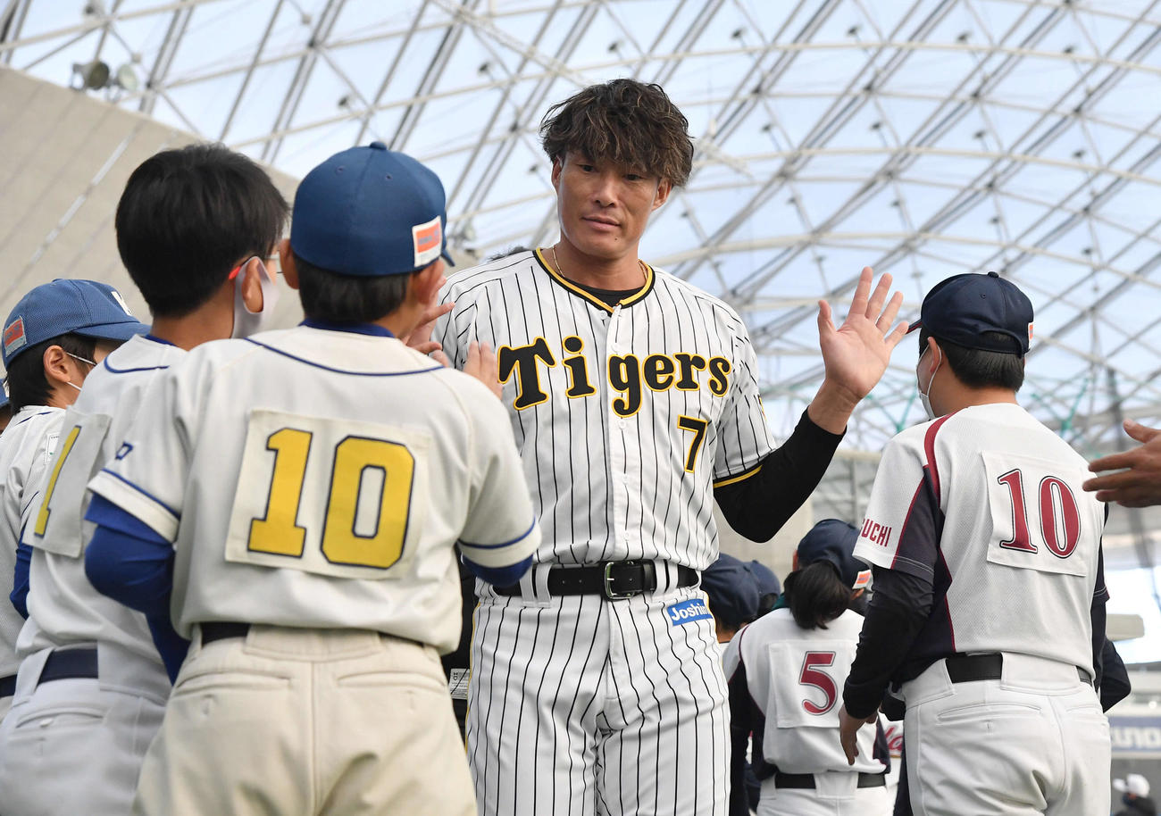 野球教室を終え、子どもたちとハイタッチしながら引き揚げる糸井氏（撮影・岩下翔太）