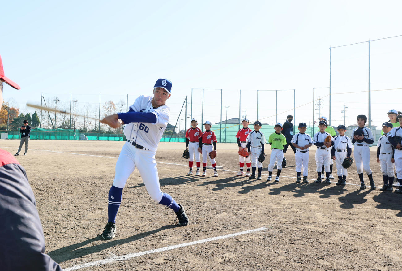 母校の菰野高校で野球教室に参加し子どもたち前でティー打撃を披露する岡林（撮影・加藤哉）