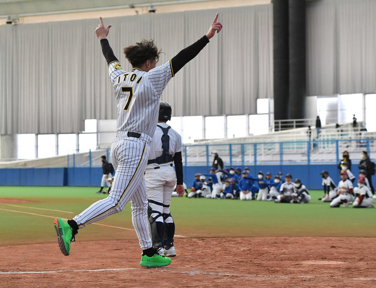 少年野球チームとの対決でランニング本塁打を放ち、両手を突き上げながら生還する糸井氏（撮影・岩下翔太）