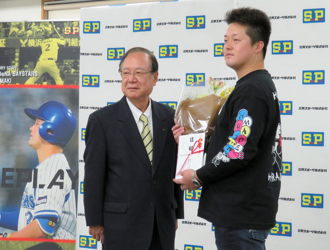「シュアプレイアドバイザリースタッフ」契約を結ぶ三共スポーツ山口泰明社長（左）からベストナイン賞受賞を祝福されるDeNA牧（撮影・鎌田直秀）