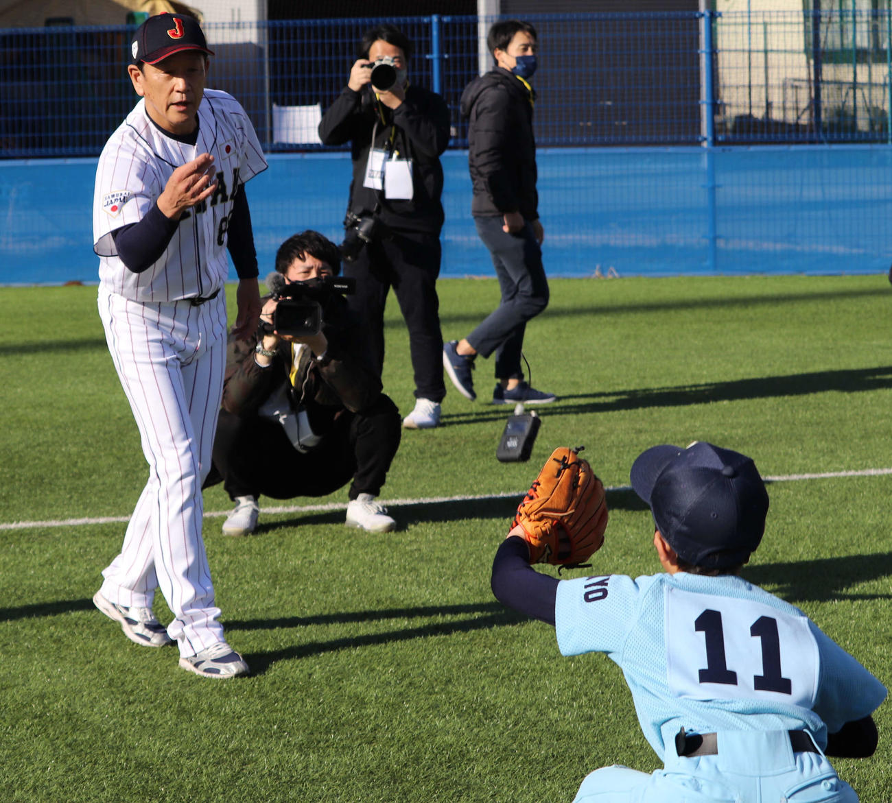 野球教室で子どもたちにキャッチボールを教える侍ジャパン栗山監督（左）。ボールではなく、中継用の機器を投げる（撮影・古川真弥）