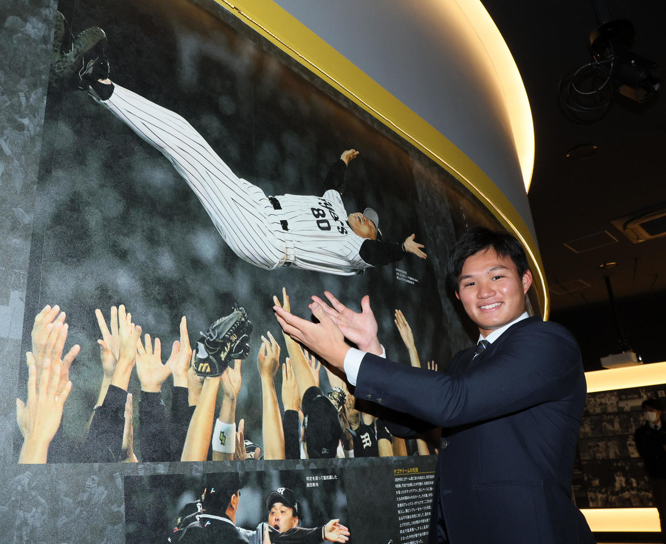 施設見学を行い歴史館で胴上げされる阪神岡田監督と写真に収まる森下翔太（撮影・加藤哉）