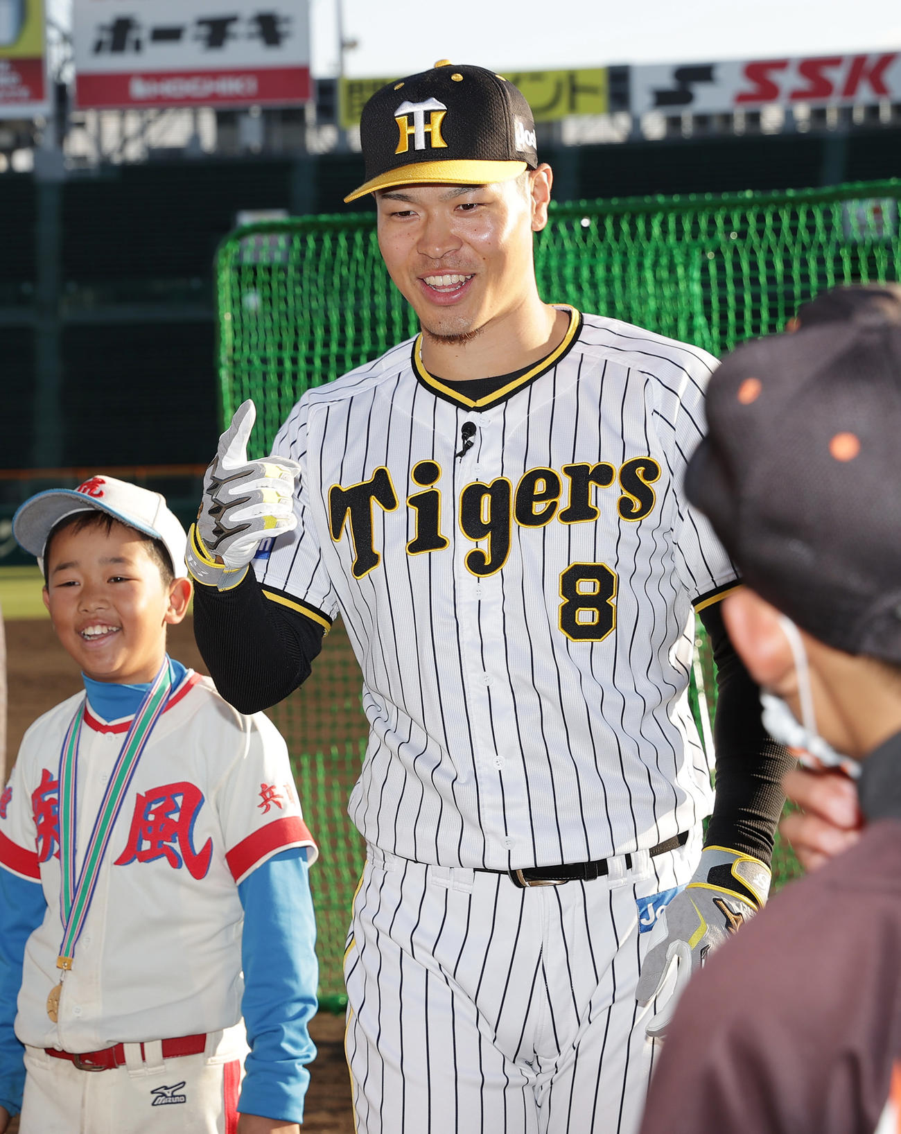 少年少女たちとのじゃんけん大会で笑顔を見せる阪神佐藤輝（中央）（撮影・前田充）