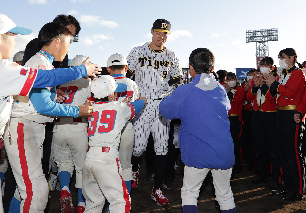 ミズノドリームカップの表彰式を終え少年少女たちに囲まれながら引き揚げる阪神佐藤輝（中央）（撮影・前田充）