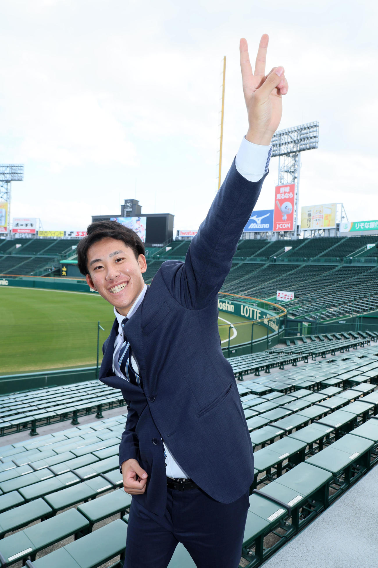 甲子園球場のアルプススタンドでポーズを決める富田（撮影・加藤哉）