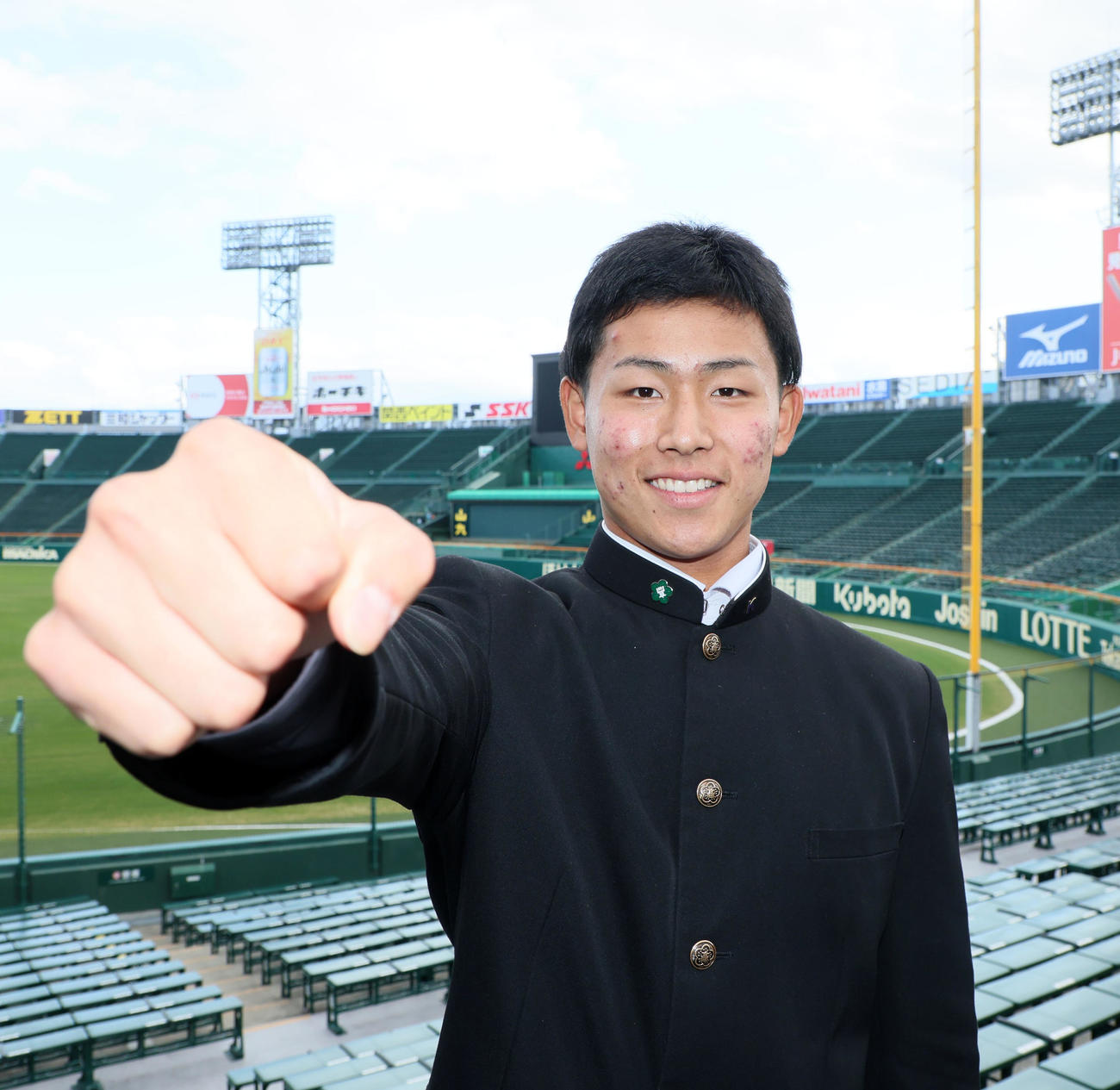 甲子園球場のアルプススタンドでポーズを決める戸井（撮影・加藤哉）