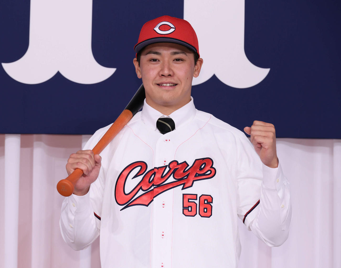 広島新入団選手発表会見　ポーズを決めるドラフト7位の久保（撮影・加藤孝規）