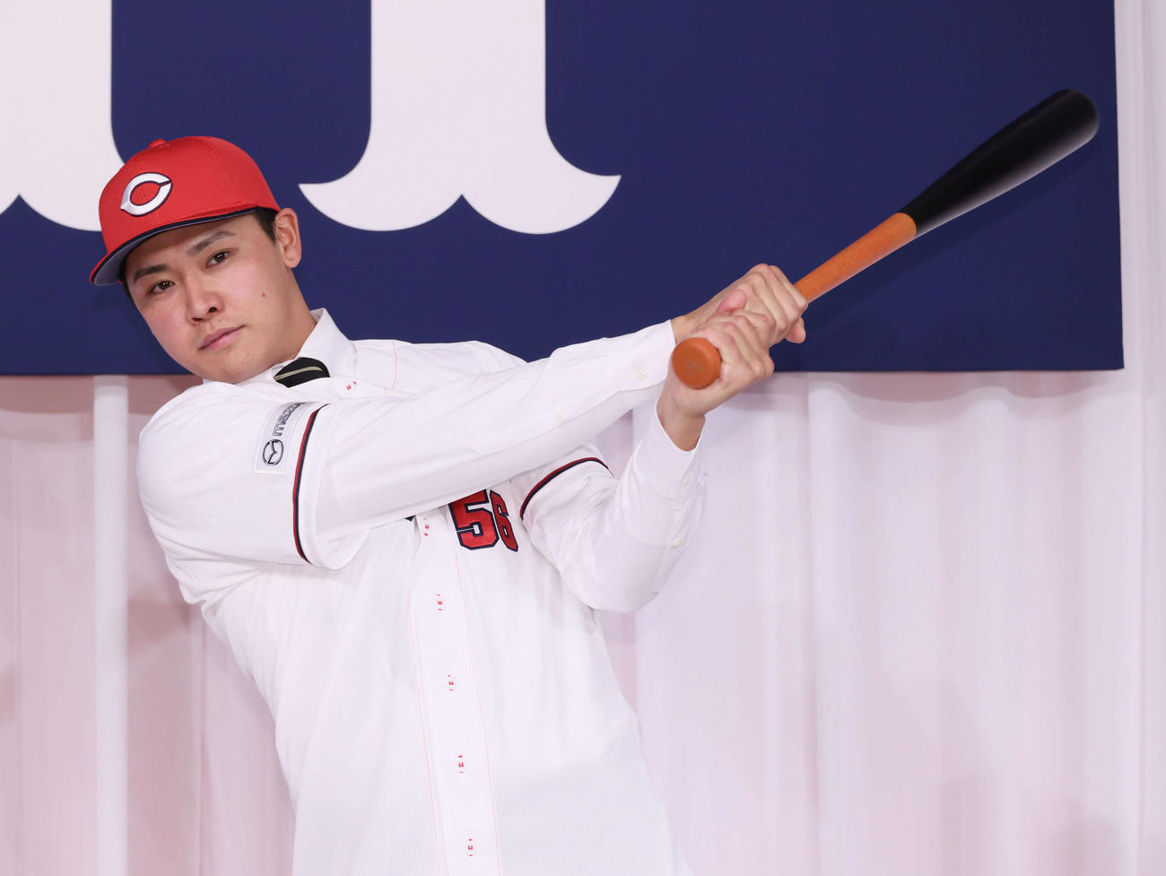 広島新入団選手発表会見　ポーズを決めるドラフト7位の久保（撮影・加藤孝規）