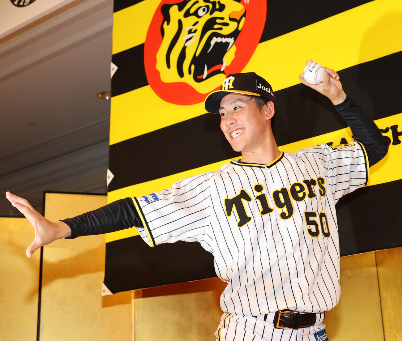 阪神ドラフト6位の富田はポーズをとって記念撮影に納まる（撮影・上山淳一）