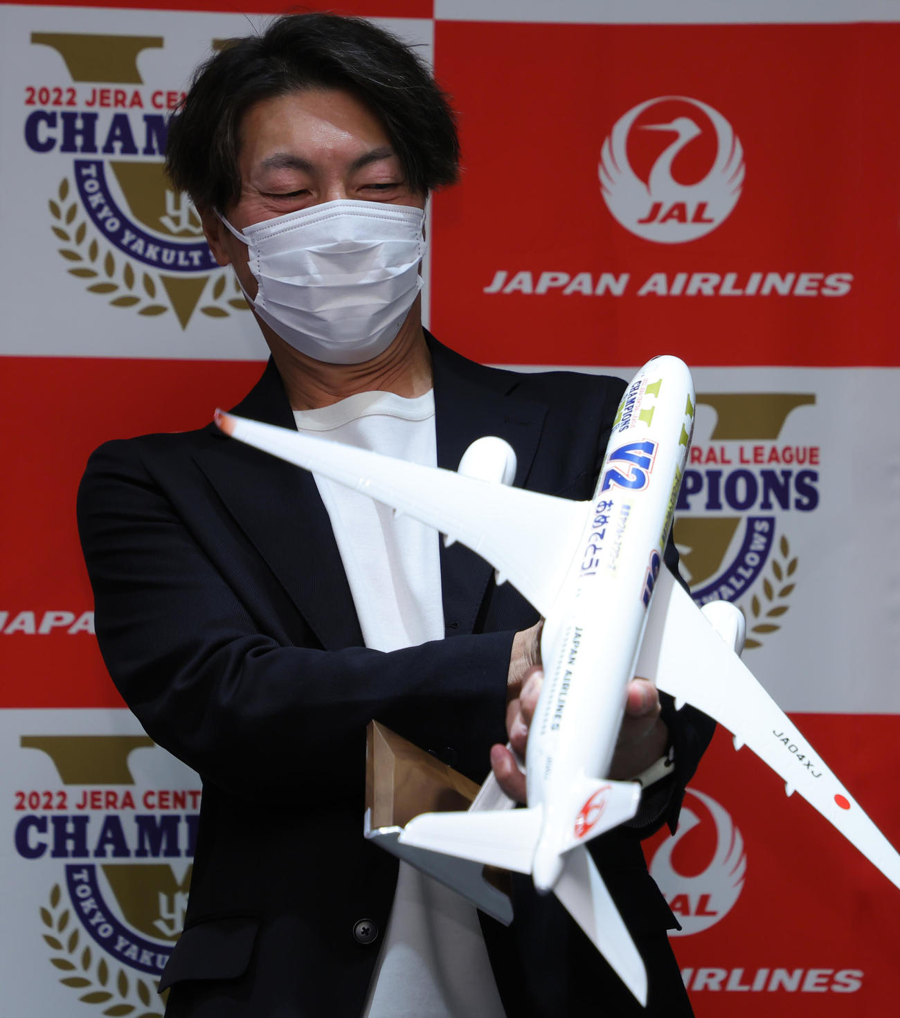 ヤクルトV旅行出発　出発式でJALから贈られた特製の飛行機の置物を興味深げに見つめる高津臣吾監督（代表撮影）