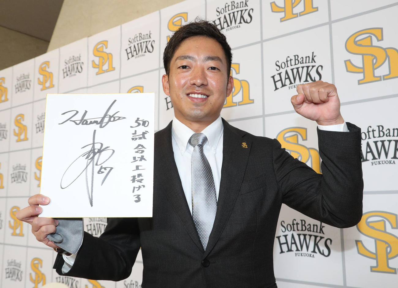 契約更改を終えた嘉弥真新也は来季の目標を色紙に記しガッツポーズ（撮影・梅根麻紀）