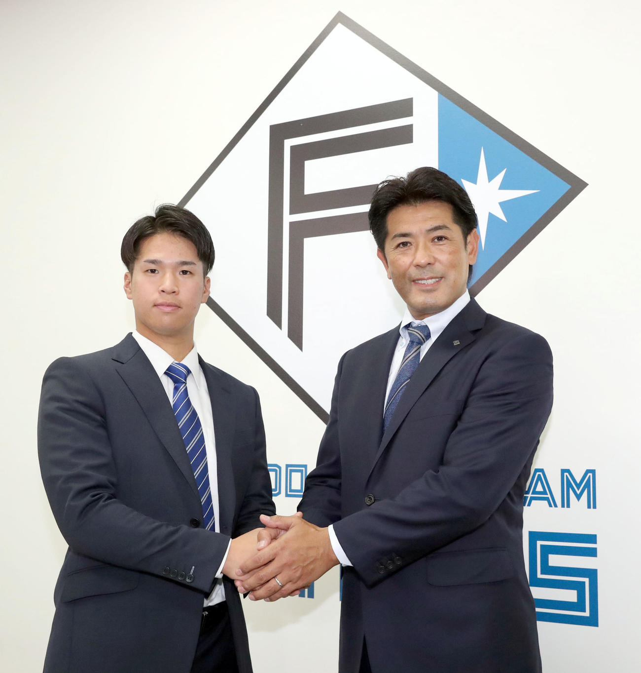 記念撮影に応じる西武から現役ドラフトで入団した日本ハム松岡（左）と稲葉GM（撮影・佐藤翔太）